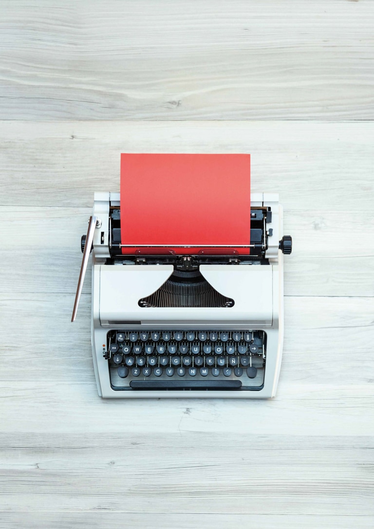 Premio Literario Vidas que Inspiran Maquina de escribir con un papel de color rojo en su interior